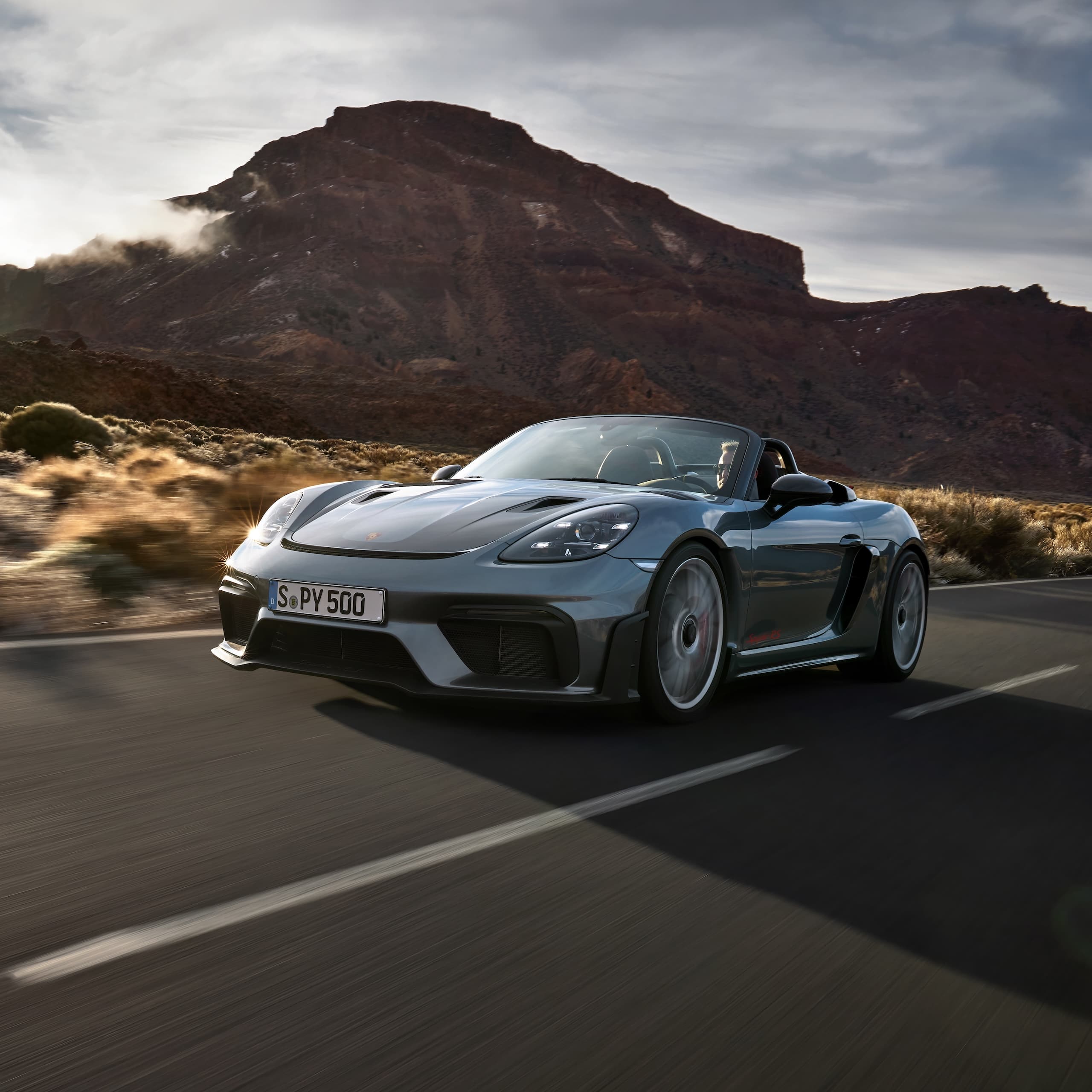 Porsche 718 Spyder RS kjører på veien mellom steinformasjoner.
